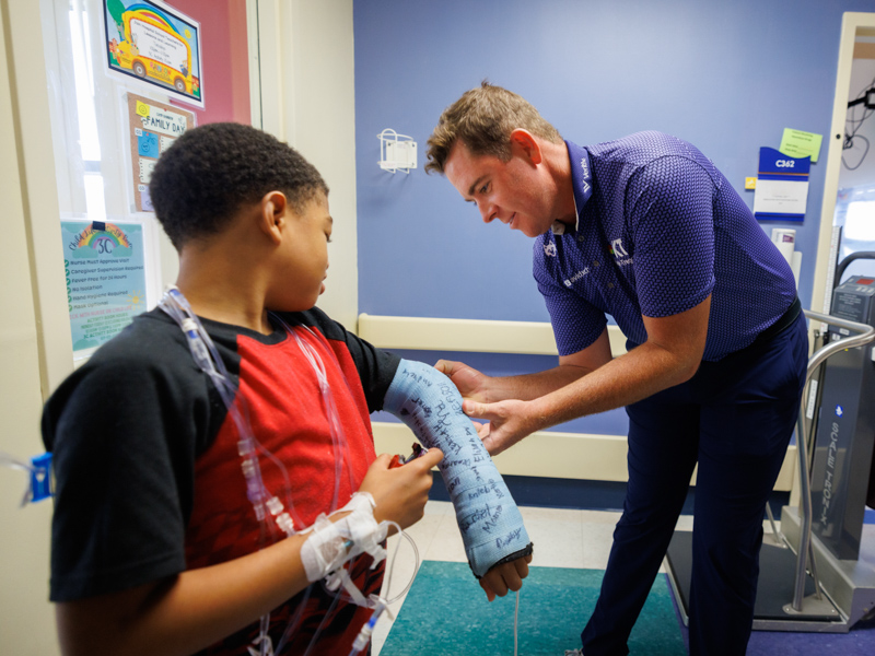 2023 Sanderson Farms Championship winner Luke List signs the cast of Children's of Mississippi patient Ricardo Davis Jr. of Ridgeland.